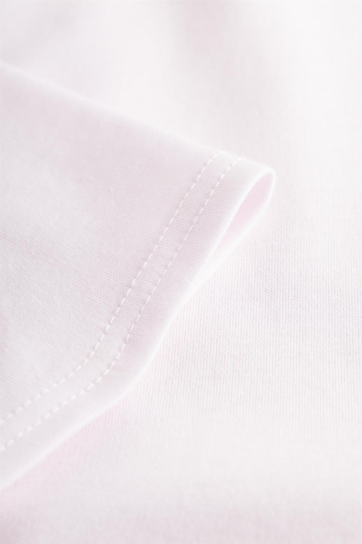 Detalj av Louis Féraud nattkjole – logo-motiv og interlock-stoff