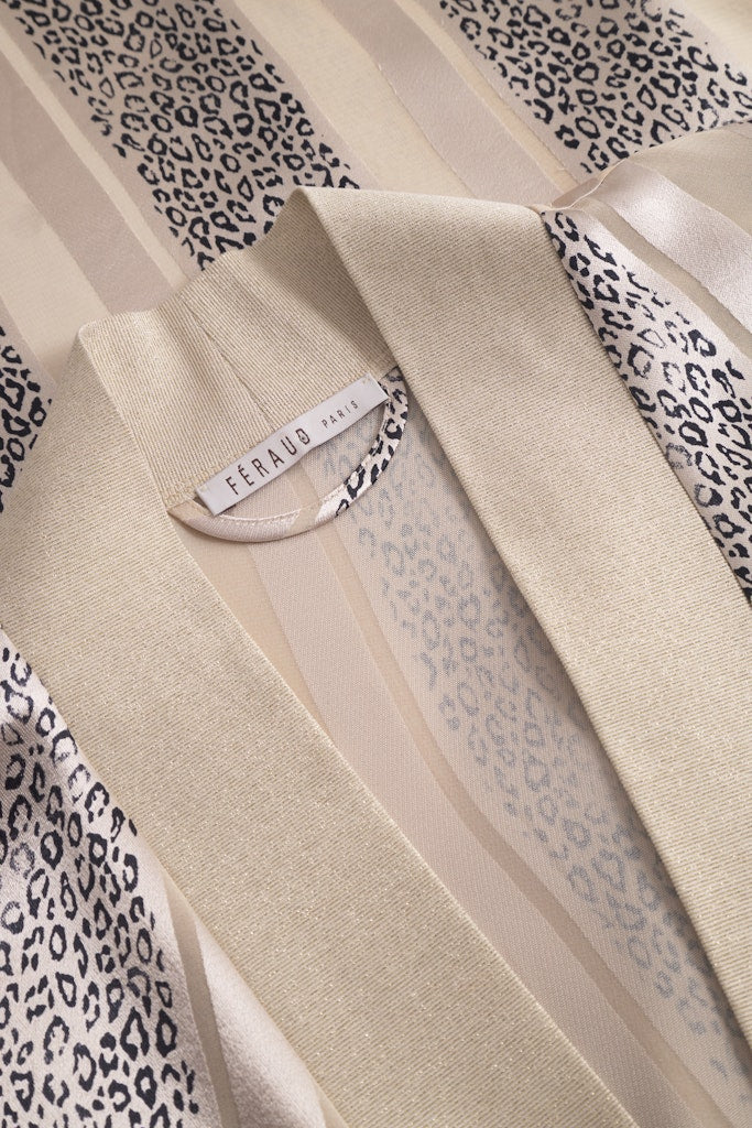 Detalj av Louis Féraud kimono – strass-logo og strukturert burnout-stoff