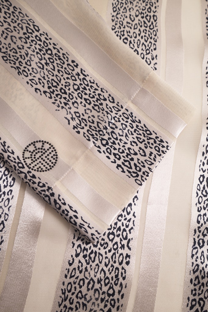 Detalj av Louis Féraud kimono – strass-logo og strukturert burnout-stoff