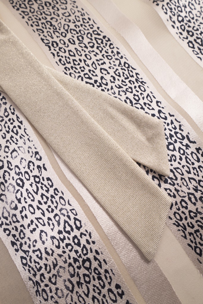 Detalj av Louis Féraud kimono – strass-logo og strukturert burnout-stoff